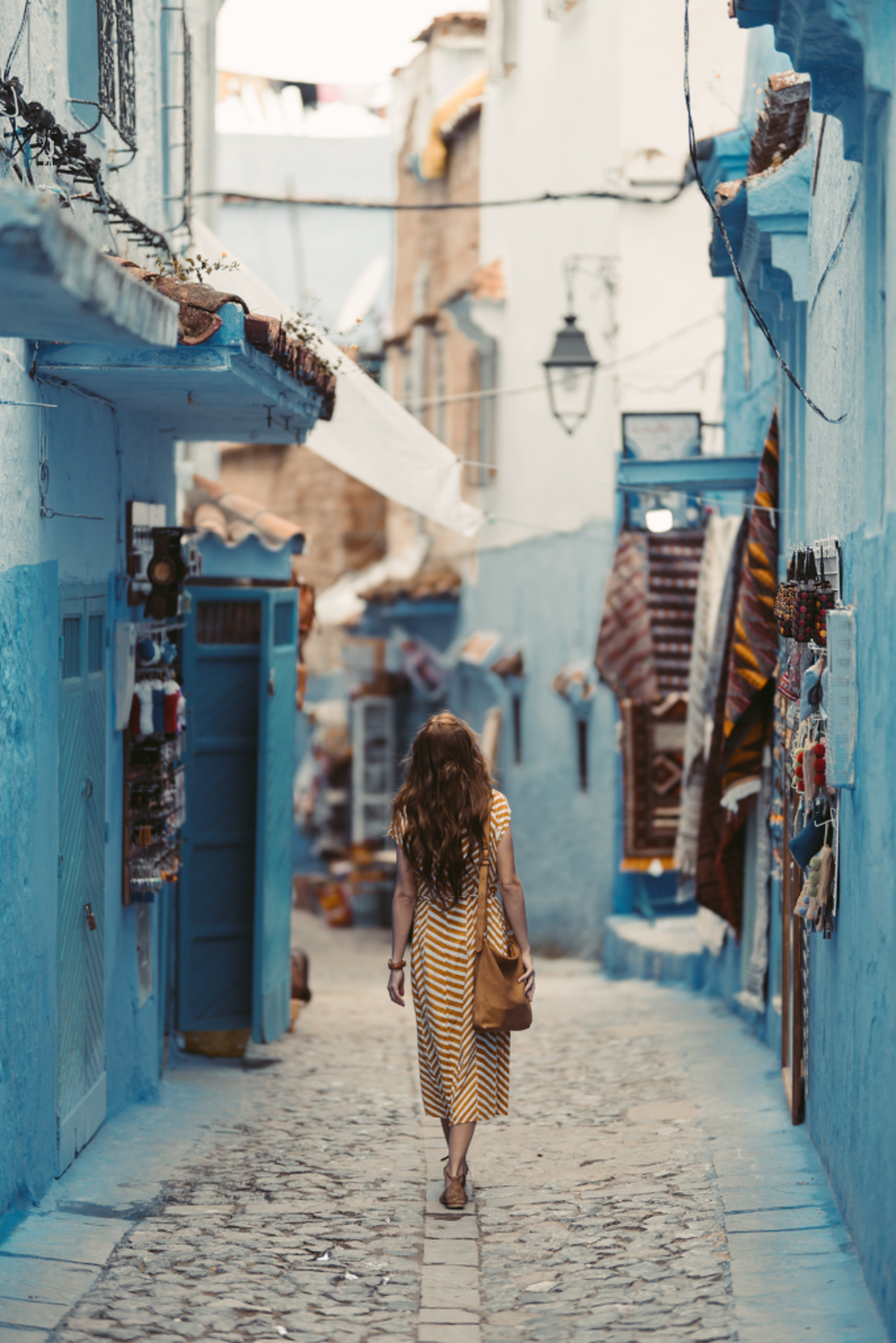 Image of a woman walking in Mororcco between shops